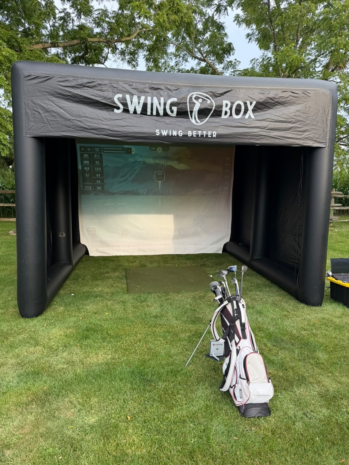 Real front view of the outdoor Swing Box enclosure, projection screen, launch monitor, clubs and laptop