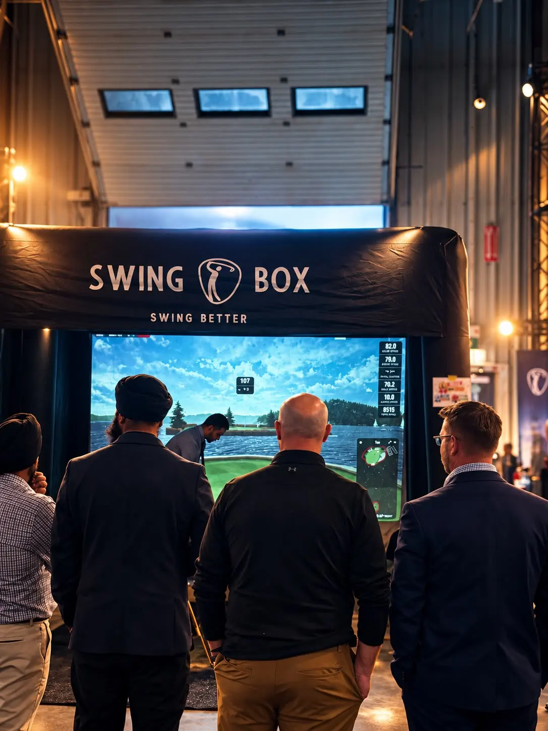 Corporate guests watching a Swing Box golf simulator at an indoor event