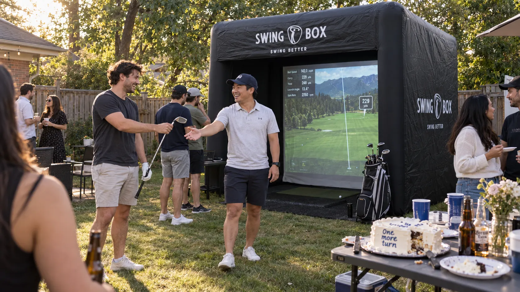 Birthday party guest passes a golf club to a friend beside Swing Box and a partly served cake