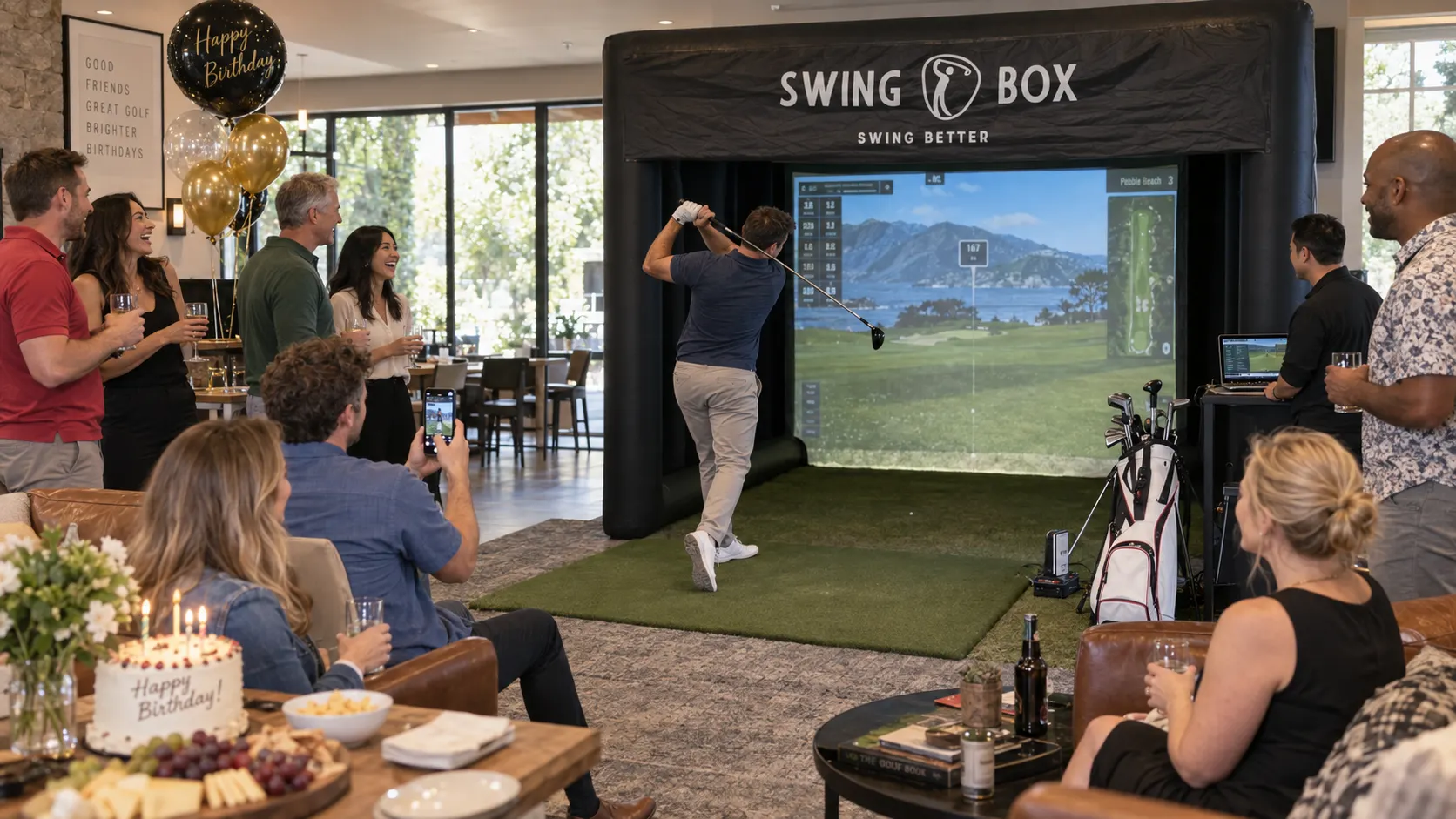 Indoor Swing Box birthday party with cake, balloons and guests watching a golf swing